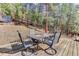Outdoor deck with dining table surrounded by lush trees at 205 Yankee Creek Trl, Evergreen, CO 80439