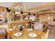 Dining area with a chandelier, wood beams, a view to the kitchen, and access to the backyard at 205 Yankee Creek Trl, Evergreen, CO 80439
