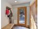Inviting entryway with wooden bench, coat rack, and exterior door, featuring natural light at 205 Yankee Creek Trl, Evergreen, CO 80439
