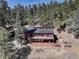 A serene home with a deck is surrounded by lush forest, offering privacy and natural beauty at 205 Yankee Creek Trl, Evergreen, CO 80439