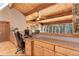 Well-lit home office featuring wood ceiling with beams, built-in desk and storage space at 205 Yankee Creek Trl, Evergreen, CO 80439