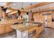 Bright kitchen features a large island with granite countertops and a gas range, and light wood cabinetry at 205 Yankee Creek Trl, Evergreen, CO 80439