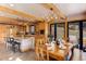 Open kitchen and dining area boasts wood cabinetry, an island, a antler chandelier, and backyard access at 205 Yankee Creek Trl, Evergreen, CO 80439