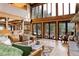 Cozy living room with high ceilings, natural wood, and oversized windows showcasing a stunning forest view at 205 Yankee Creek Trl, Evergreen, CO 80439