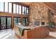 Stunning living room featuring floor-to-ceiling windows, a stone fireplace, and cozy seating at 205 Yankee Creek Trl, Evergreen, CO 80439