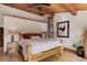 Comfortable bedroom with rustic wood bed frame, light wood floors, and natural lighting at 205 Yankee Creek Trl, Evergreen, CO 80439