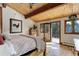 Inviting bedroom with wood ceiling, balcony access, and light hardwood floors at 205 Yankee Creek Trl, Evergreen, CO 80439