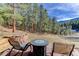 Outdoor patio with rock fire pit and views of the forested backyard at 205 Yankee Creek Trl, Evergreen, CO 80439