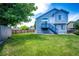 Spacious backyard features well-maintained green lawn and a two-story home with stairs to a small deck at 8930 Apache Plume Dr, Parker, CO 80134
