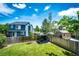 Landscaped backyard featuring green grass, pergola with seating, storage shed, and a wooden fence at 8930 Apache Plume Dr, Parker, CO 80134