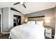 This bedroom features carpet floors, a ceiling fan, a bed, and a closet with a view of the bathroom at 8930 Apache Plume Dr, Parker, CO 80134