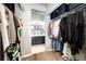 Walk-in closet with clothes, shoes, and storage boxes, leading to the bathroom with a double vanity at 8930 Apache Plume Dr, Parker, CO 80134