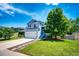 Beautiful two-story home with blue siding, front lawn, and concrete driveway at 8930 Apache Plume Dr, Parker, CO 80134