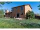 Backyard view of home with sliding glass door and small deck at 11098 Fairfax Way, Thornton, CO 80233