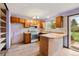 Cozy kitchen with wooden cabinets, wood-style flooring, and view to the back yard through the sliding door at 11098 Fairfax Way, Thornton, CO 80233