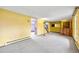 Spacious living room with carpet flooring, yellow walls, and staircase to the upper level at 11098 Fairfax Way, Thornton, CO 80233