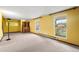 Large living room with carpet flooring, bright walls, and view of backyard through the windows at 11098 Fairfax Way, Thornton, CO 80233