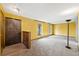 Bright living room with carpet flooring, yellow walls, and large windows offering natural light at 11098 Fairfax Way, Thornton, CO 80233