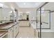 Luxurious bathroom featuring a large tub, dual vanities, and a glass-enclosed shower at 49 Willowcroft Dr, Littleton, CO 80123