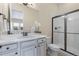 Bright bathroom with a shower, dark hardware, and a white vanity and countertop at 49 Willowcroft Dr, Littleton, CO 80123