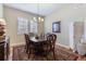 Formal dining room with dark wood table, chairs, chandelier, rug and shutters on the windows at 49 Willowcroft Dr, Littleton, CO 80123