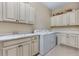 Functional laundry room with a sink, counter space, washer, dryer, and upper cabinets at 49 Willowcroft Dr, Littleton, CO 80123