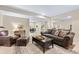 Open-concept living room with neutral tones, plush sofa, and seamless flow to dining area at 49 Willowcroft Dr, Littleton, CO 80123