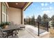 Inviting covered patio with wrought iron furniture overlooking professionally landscaped grounds at 49 Willowcroft Dr, Littleton, CO 80123
