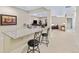 Stylish wet bar boasts granite countertops, seating, and seamless access to other living areas at 49 Willowcroft Dr, Littleton, CO 80123