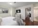 Bedroom with a mounted TV, dresser, and access to closet and bathroom at 7205 S Gaylord St # F15, Littleton, CO 80122