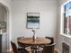 Cozy dining area with a wooden table, modern art, and natural light from the window at 1130 N N Pennsylvania St # 306, Denver, CO 80203