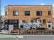 An exterior shot shows the brick building with a mural and outdoor seating of the bar and restaurant at 1130 N N Pennsylvania St # 306, Denver, CO 80203