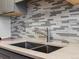 Close up of a stainless steel kitchen sink, faucet and granite countertops at 1130 N N Pennsylvania St # 306, Denver, CO 80203