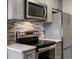 Modern kitchen includes stainless steel appliances and a mosaic tile backsplash at 1130 N N Pennsylvania St # 306, Denver, CO 80203