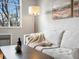 Cozy living room with stylish lamp, neutral tones, and a large window for natural light at 1130 N N Pennsylvania St # 306, Denver, CO 80203