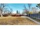 Spacious backyard with a wooden fence, mature trees, and a patio, providing a private and serene outdoor space at 7248 S Broadway, Centennial, CO 80122