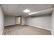 Finished basement area with neutral carpet, drop ceiling, and access to a utility room at 7248 S Broadway, Centennial, CO 80122