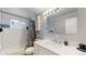 Well-lit bathroom features a shower-tub combo, tiled walls, and a modern vanity with ample counter space at 7248 S Broadway, Centennial, CO 80122