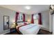 Cozy bedroom with wood floors, red accents, and natural light from the two windows at 7248 S Broadway, Centennial, CO 80122