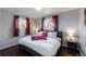Bright bedroom with hardwood floors, comfortable bed with stylish linens, and natural light from windows at 7248 S Broadway, Centennial, CO 80122