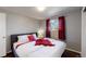 Bright bedroom with hardwood floors, comfortable bed with stylish linens, and natural light from the window at 7248 S Broadway, Centennial, CO 80122