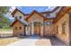 Charming stone exterior with a custom wood front door and manicured landscaping at 11790 Huckleberry Drive Dr, Franktown, CO 80116