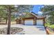 Stone home features a three-car garage, mature trees, and a circular driveway at 11790 Huckleberry Drive Dr, Franktown, CO 80116