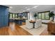 Open kitchen and dining area with blue cabinets, wood floors, an island, and a large window at 11790 Huckleberry Drive Dr, Franktown, CO 80116