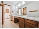 Bathroom featuring double sinks, marble countertops, and wood cabinets at 10262 W Ida Ave # 243, Littleton, CO 80127