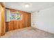 Cozy bedroom featuring wood paneling, carpeted floor and large window at 10262 W Ida Ave # 243, Littleton, CO 80127