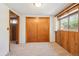 Comfortable bedroom features a spacious closet, wood paneling, and neutral carpet with natural light at 10262 W Ida Ave # 243, Littleton, CO 80127