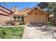 Exterior view of home featuring a two-car garage, well-maintained lawn, and inviting curb appeal at 10262 W Ida Ave # 243, Littleton, CO 80127