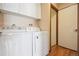Functional laundry room with washer, dryer, and overhead cabinets for storage at 10262 W Ida Ave # 243, Littleton, CO 80127
