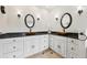 Bathroom featuring double vessel sinks and black countertops with white cabinetry at 9385 Prairie View Dr, Highlands Ranch, CO 80126